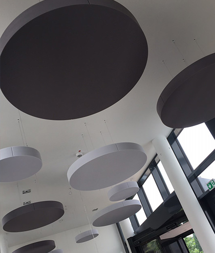 Round acoustic ceiling sails in a dining room reduce noise.